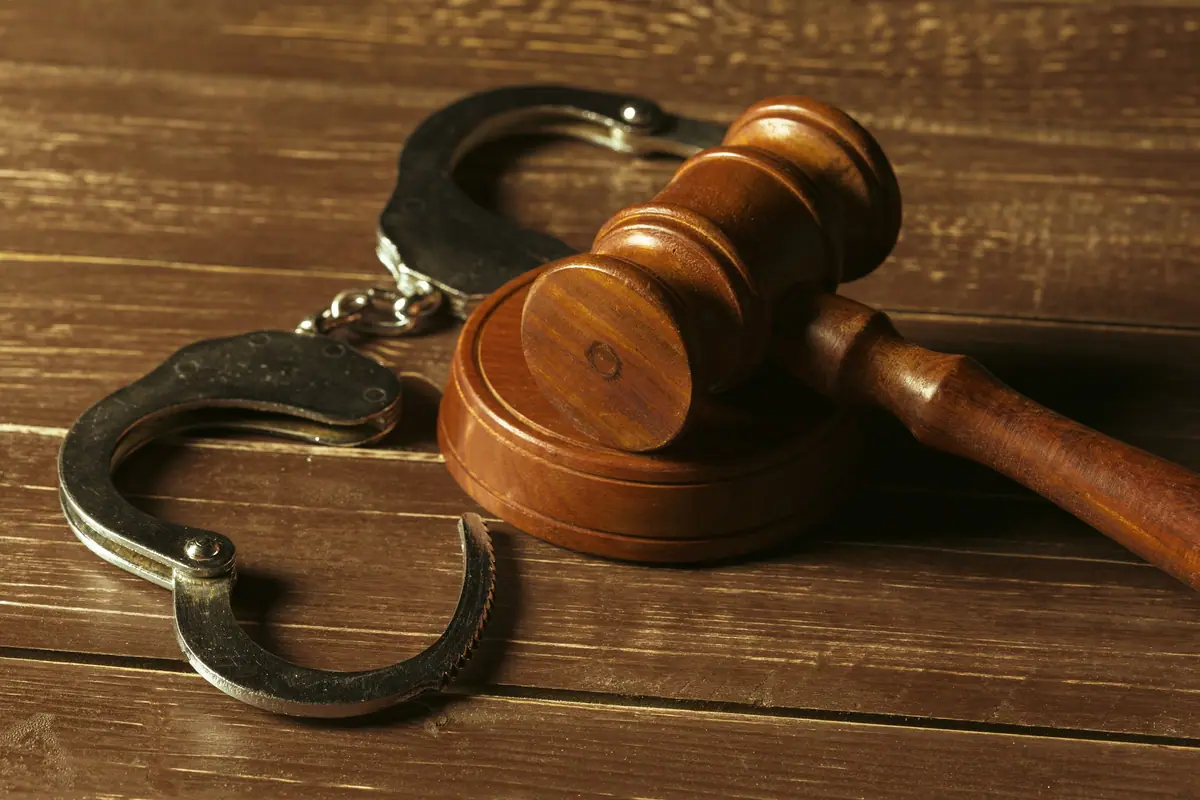 Handcuffs beside a judge’s gavel